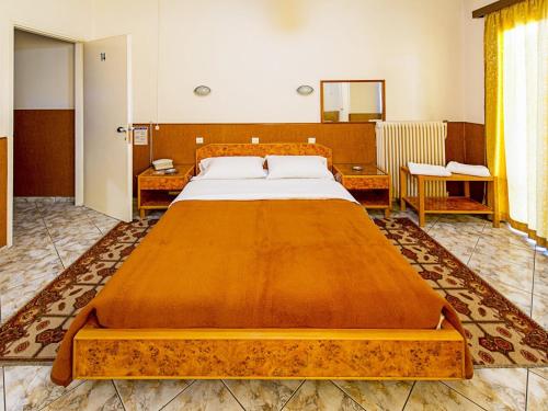ein Schlafzimmer mit einem großen Holzbett in einem Zimmer in der Unterkunft Aegli Hotel in Athen