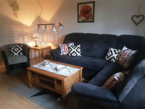 a living room with a blue couch and a coffee table at -Heaf half between North and Ostsee U Schlei in Ellingstedt