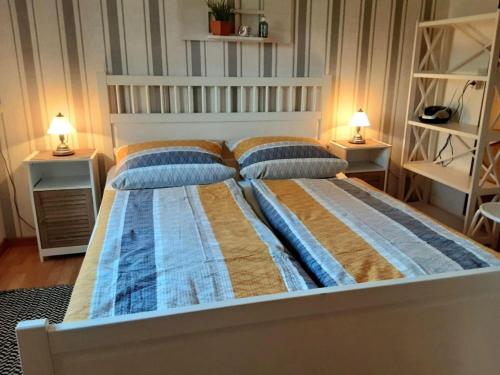 a bedroom with a bed with two pillows and two lamps at -Heaf half between North and Ostsee U Schlei in Ellingstedt