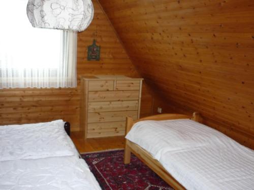 a bedroom with two beds in a log cabin at North Sea holiday house Wellmeyer in Spieka-Neufeld