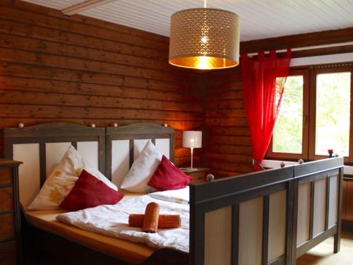 um quarto com uma cama com almofadas vermelhas e brancas em Holiday home Schleiblick em Gunneby