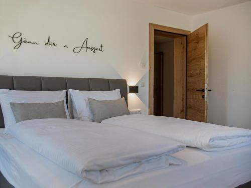 un grand lit blanc avec un panneau indiquant que quelqu'un a fait une pomme dans l'établissement Green Residence L I, à Wildschönau