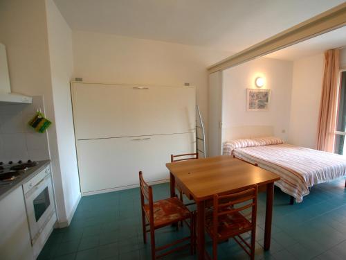 a small kitchen with a table and a refrigerator at Residence Maricampo in Marina di Campo