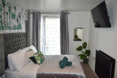 a bedroom with a bed and a large window at Tottenham Hotspurs Stays at the Gascoigne Suite in London