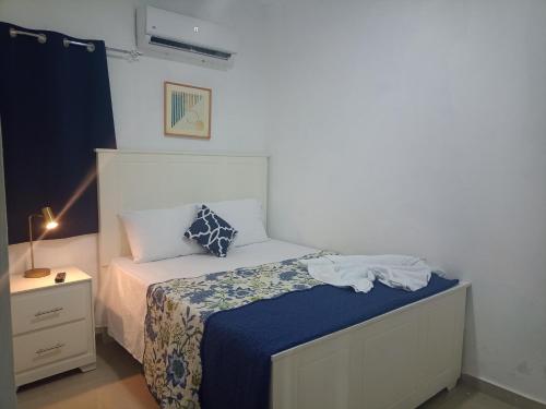 a small bedroom with a bed and a night stand at DaDaJuBa Aparta hotel in Santa Bárbara de Samaná