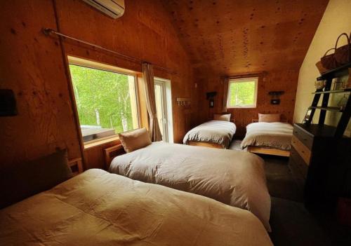 two beds in a room with a window at Kamaitai Inn ONE and ONLY - Vacation STAY 65431v in Biei
