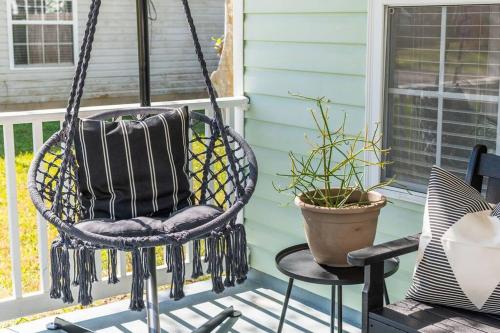 a swing on a porch with two chairs and a plant at The Emerald of St. Augustine in St. Augustine