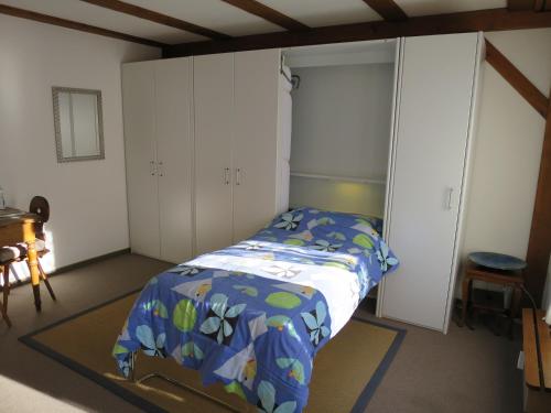 Schlafzimmer mit einem Bett und weißen Schränken in der Unterkunft Chli Alpa B13 in Arosa