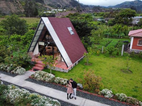 two people standing in front of a small house at Destinos Exclusivos Patate in Patate