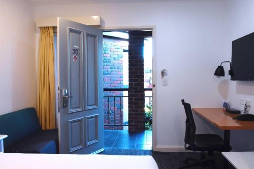 a room with a door and a desk and a deskablish at Best Western Plus Buckingham International in Moorabbin