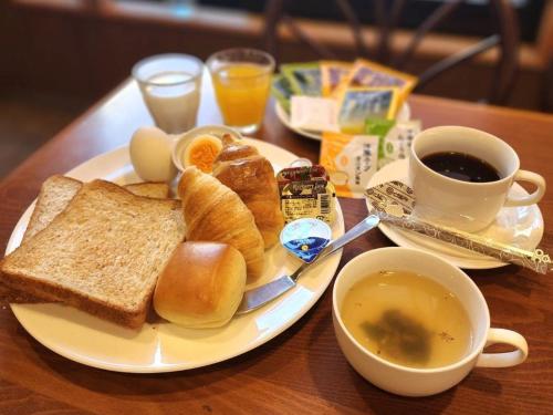a plate of breakfast food with toast and coffee on a table at Hotel Hana in Takayama