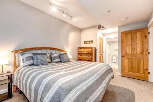 a bedroom with a large bed with blue pillows at Cozy Crestview Condo in Park City