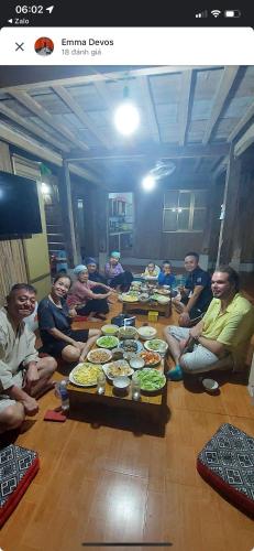 a group of people sitting around a table with food at Mai Chau Home Holiday in Mai Chau