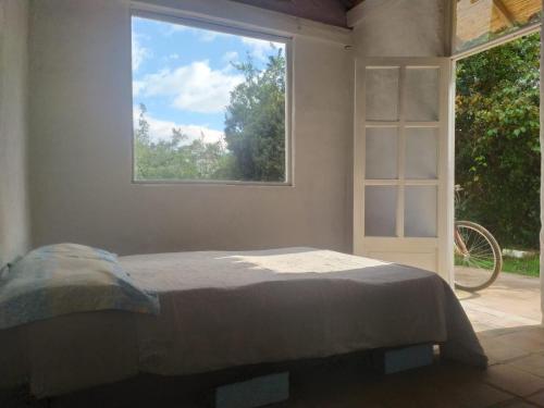 um quarto com uma cama e uma janela em El chalet de Agnes em Villa de Leyva