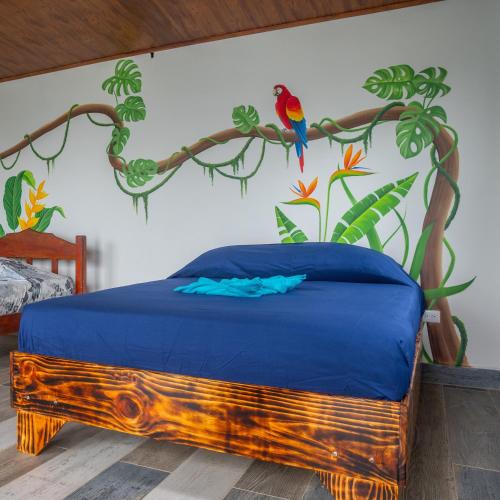 a bedroom with a bed with a bird on the wall at Ecolodge Kalaluna Resort in Drake