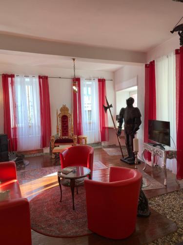 a living room with red chairs and a statue in the middle at Count von Hatzfeld mit Moselblick in Kinheim