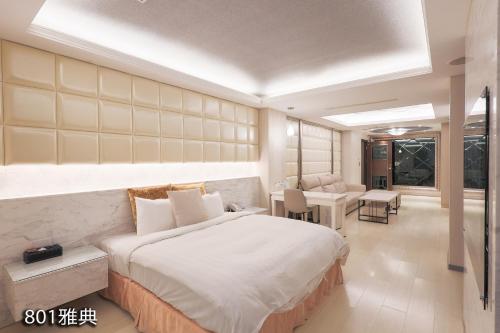 a bedroom with a large bed and a living room at Chimei Fashion Hotel in Zhongli