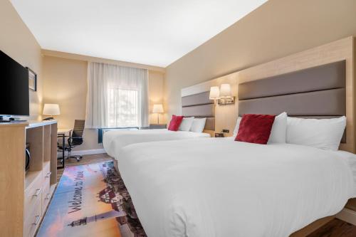 a hotel room with two beds and a television at Casco Bay Hotel Portland Airport - Maine Mall, an Ascend Collection Hotel in South Portland