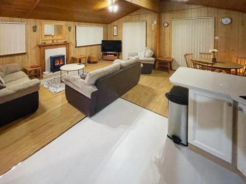 ein großes Wohnzimmer mit Sofas und einem Kamin in der Unterkunft The Hive in Warmwell