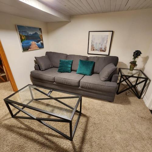 sala de estar con sofá y mesa de cristal en The Weber Suite, en Kitchener