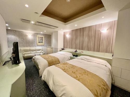 um quarto de hotel com três camas e uma televisão em SKY Lmine Takeo LOVEHOTEL em Takeo