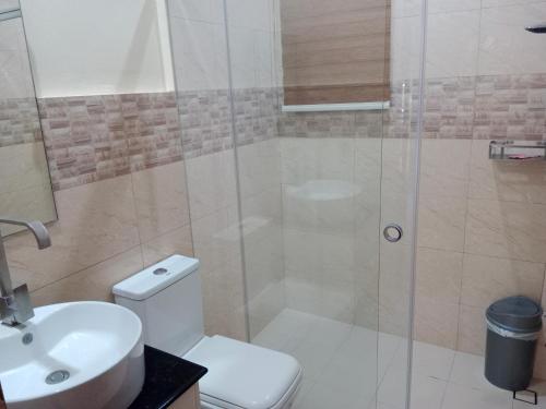 a bathroom with a shower and a toilet and a sink at Villa Marilyn Resort and Hotel in Coron