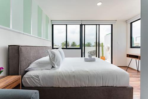 a bedroom with a large bed with white sheets at Narvarte Apartments by Escajal Homes in Mexico City