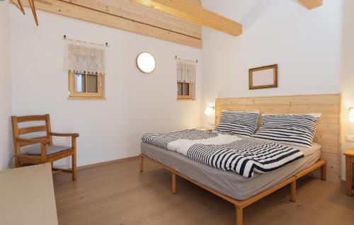 um quarto com uma cama e uma cadeira de madeira em 1 Bedroom Cozy Home In Gssing em Güssing