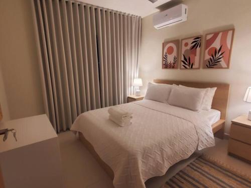 een slaapkamer met een wit bed en een raam bij Escapada en Boca chica in Boca Chica