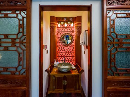a bathroom with a sink and a mirror at Datong Yunzhong Traditional Courtyard in Datong