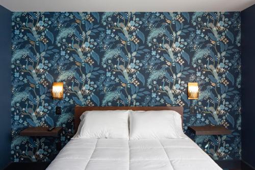 a bedroom with a bed with a blue floral wallpaper at Shelburne Springs Hotel in Shelburne Falls