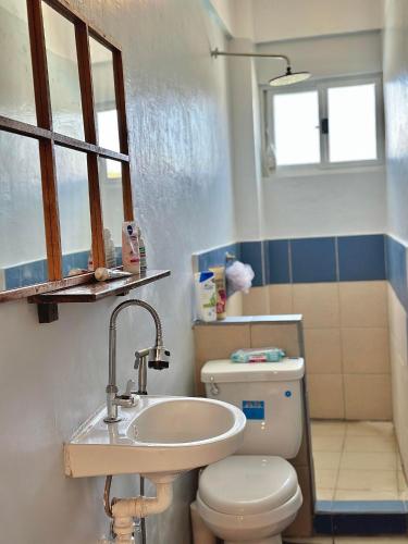 a bathroom with a white toilet and a sink at Bahai ni Jhane in Calatagan