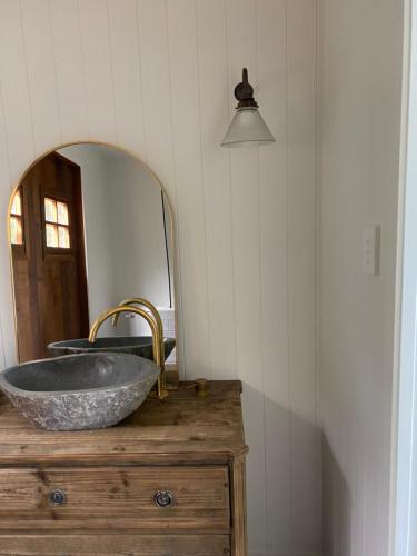 a bathroom with a stone sink and a mirror at Ocean Beach in Tuki Tuki