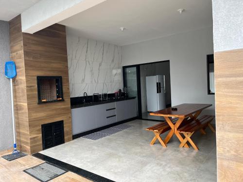 a kitchen with a wooden table and a refrigerator at Casa Esmeralda in Guaratuba