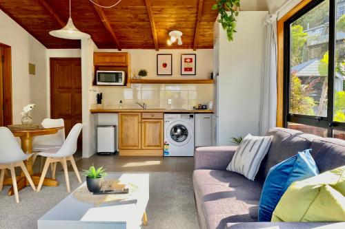 a living room with a couch and a kitchen at The Swiss Chalet Apartment 9 - Seaview - Top Floor - Air Conditioning & Wi-Fi - Bay of Islands in Paihia