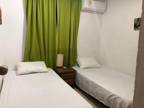 twee bedden in een kamer met een groen gordijn bij cómodo apartamento 3 alcobas in Barranquilla