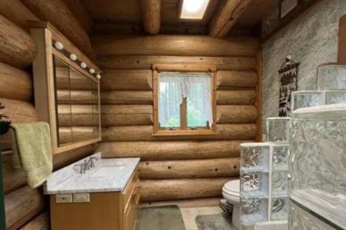 een houten badkamer met een toilet en een wastafel bij Chapel Forest Cabin in Shingleton