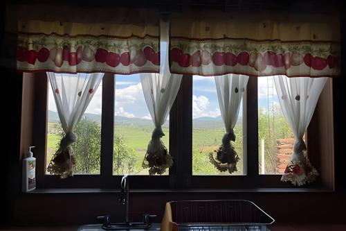 a window with curtains and a view of a field at Cabaña Bechamel, Tapalpa in Tapalpa
