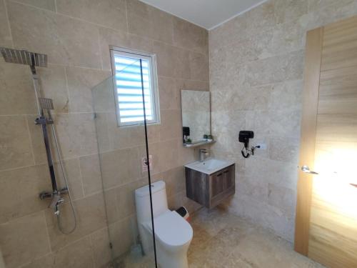 a bathroom with a toilet and a shower and a sink at Villa en Puerto Plata in San Felipe de Puerto Plata