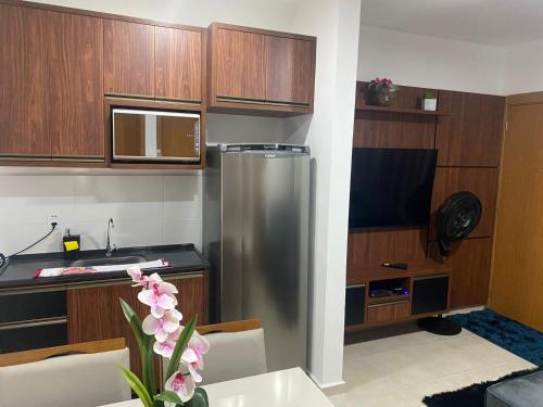 a kitchen with a stainless steel refrigerator and wooden cabinets at Apartamento Lindo e Aconchegante in São José