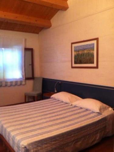 安科納的住宿－阿奇皮茨亞農莊酒店，一间带床的卧室,位于带窗户的房间内