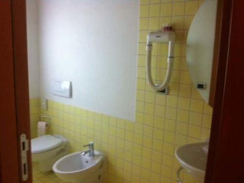 uma casa de banho em azulejos amarelos com um lavatório e um WC em Agriturismo Accipicchia em Ancona