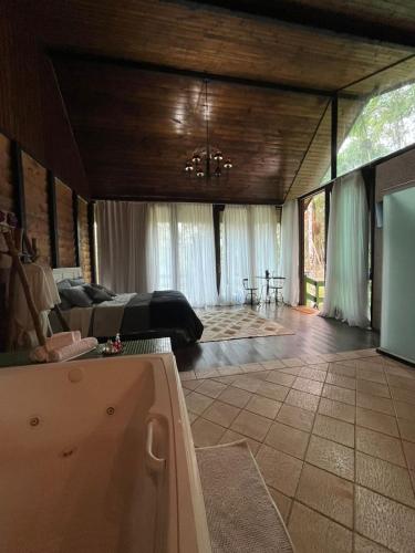 a large living room with a bed and a tub at Recanto dos Sonhos Guest House in Lumiar