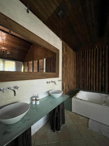 a bathroom with two sinks and a bath tub at Recanto dos Sonhos Guest House in Lumiar