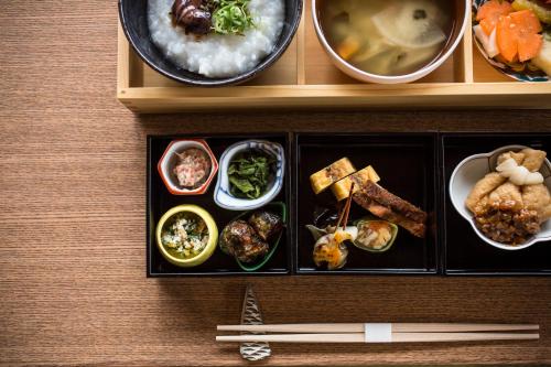 een dienblad met eten op een houten tafel met eetstokjes bij Sumihei Bettei Toki Toki in Kinosaki