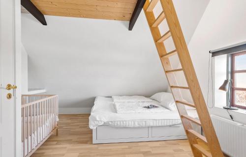 Habitación pequeña con cama y escalera en Awesome Home In Tranekr With Kitchen, en Tranekær