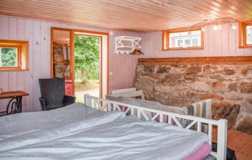 een slaapkamer met een bed en een stenen muur bij Cozy Home In Tving With Wifi in Tving