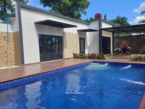 a house with a swimming pool in front of a house at Quinta Villateo in Villavicencio