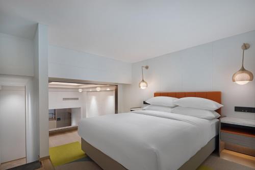 a bedroom with a large white bed with white pillows at Home2 Suite by Hilton Chongqing South Bank in Chongqing