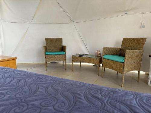 two chairs and a bed in a tent at Amaj Eco Lodge in Sámara